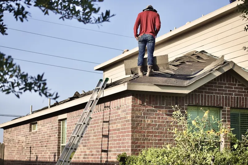 Professional roofer working on a residential roof in West Quincy